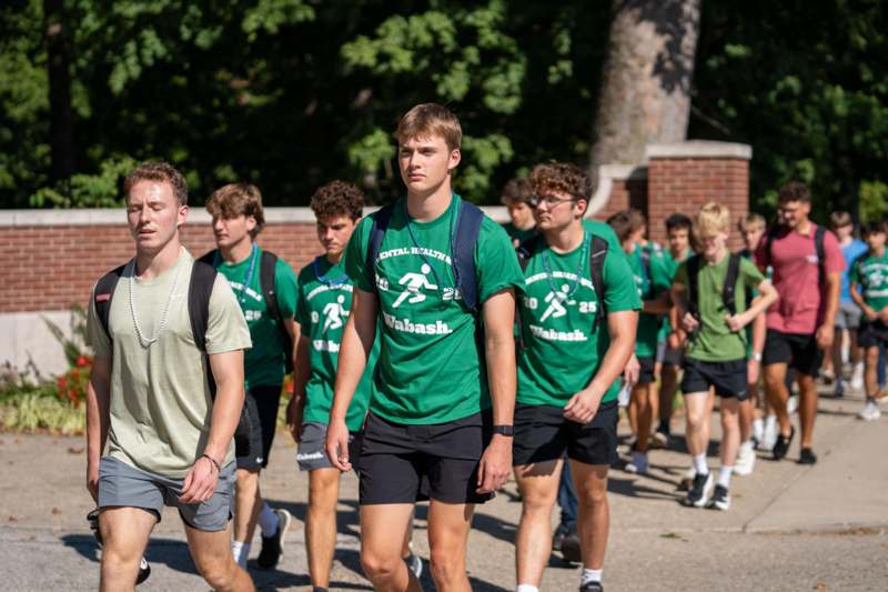 a group of men walking on a sidewalk