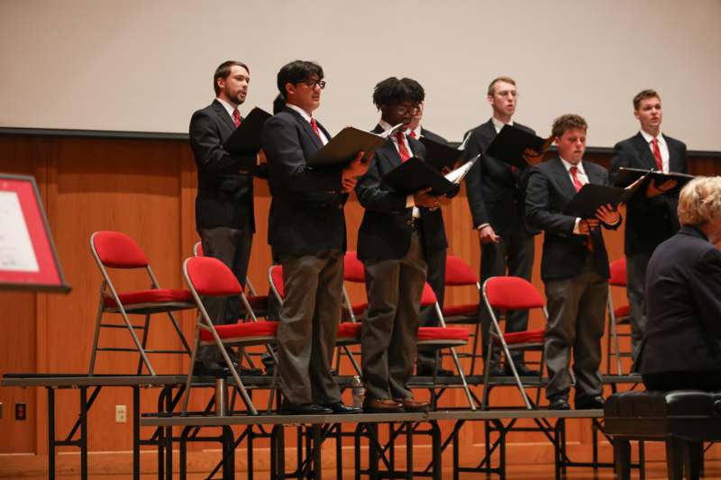 a group of men singing on a stage