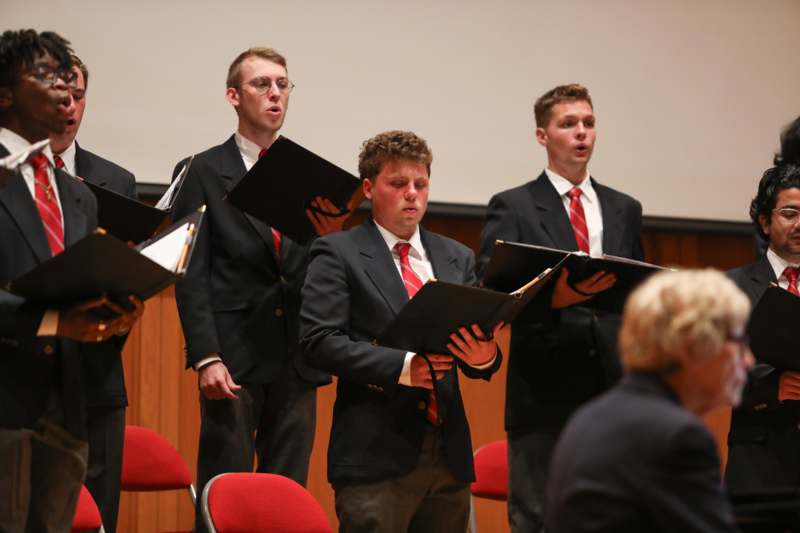 a group of men singing in a choir