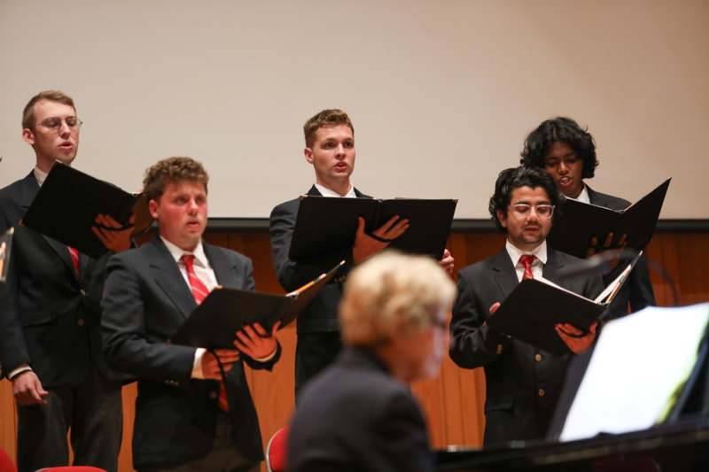 a group of people holding music books