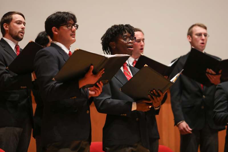 a group of men in suits holding folders