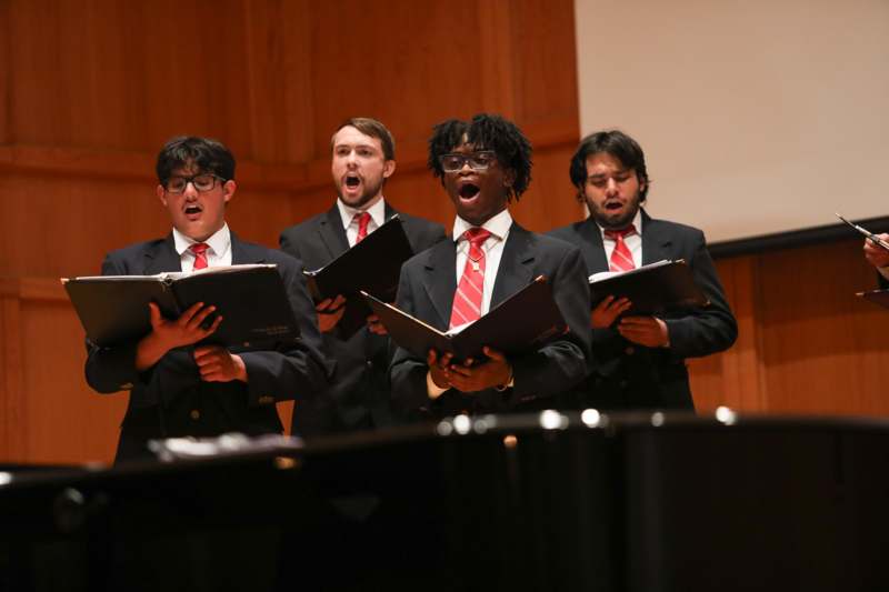 a group of men singing in a choir