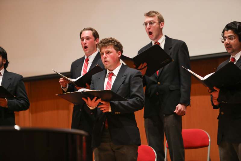 a group of men singing in a concert