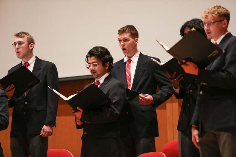a group of men in suits holding folders
