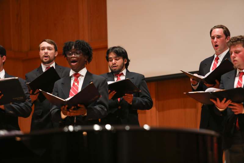 a group of men singing in a room