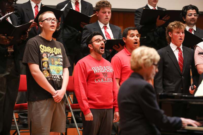 a group of people singing in front of a woman