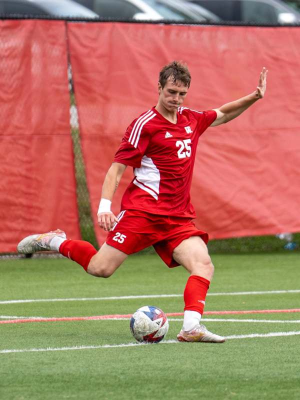 a man in a red uniform kicking a football ball