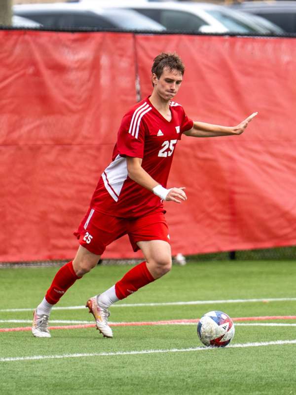 a man in a red uniform kicking a football ball