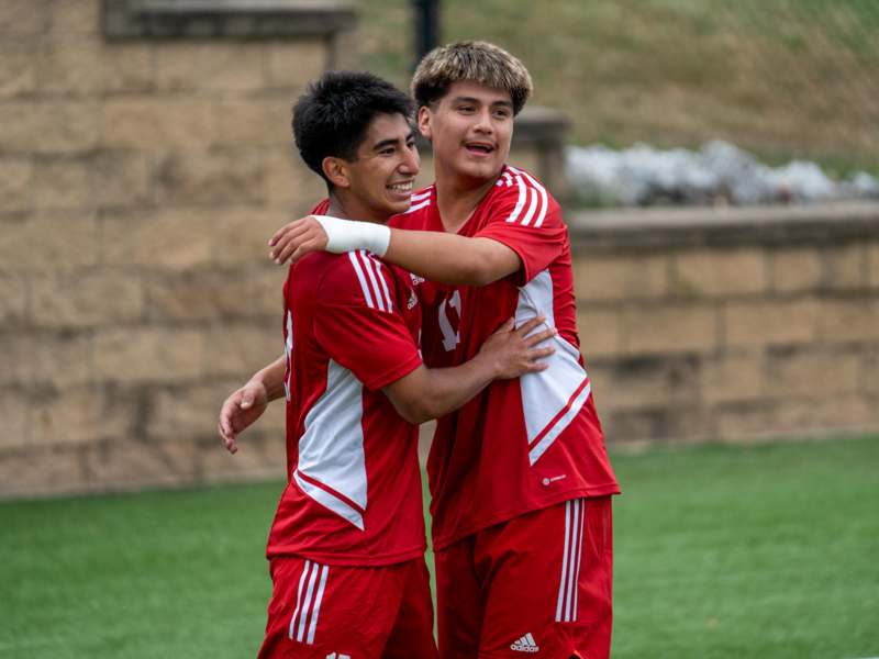 two men in red uniforms hugging