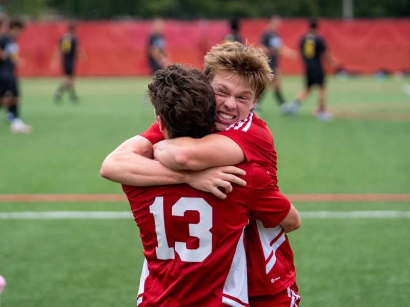 two men hugging on a field