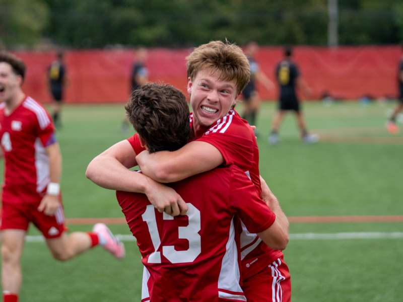 two men hugging on a field