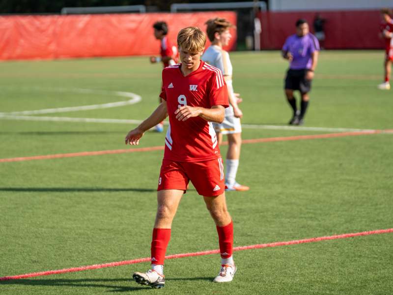 a man in a red uniform on a field