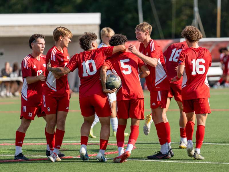 a group of men in red uniforms on a field