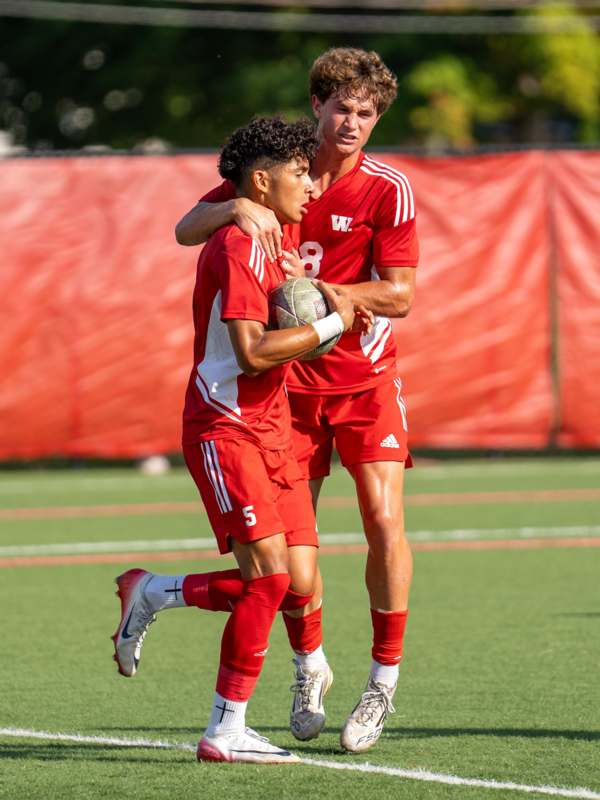 two men in red uniforms on a field