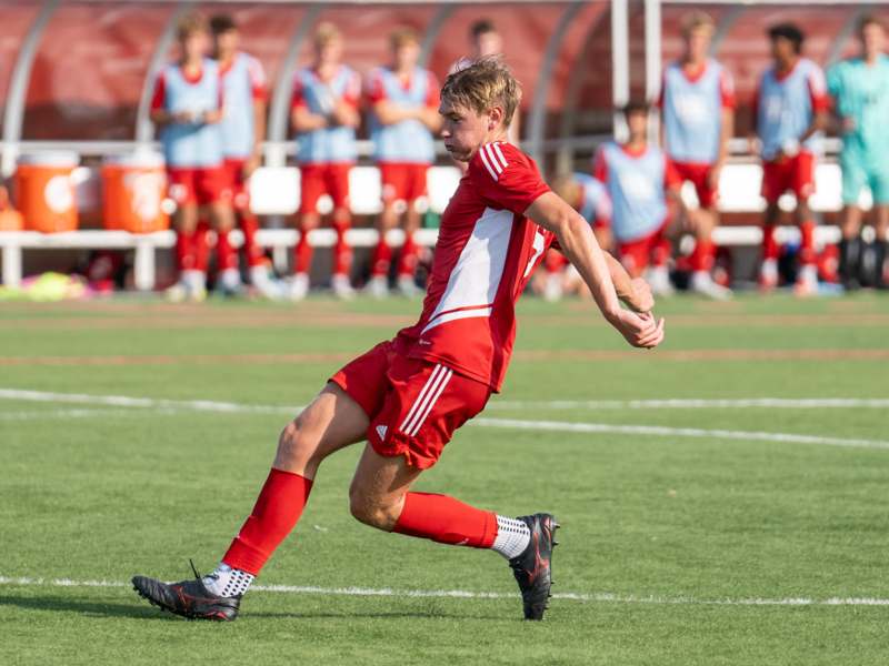 a man in a red uniform running on a field