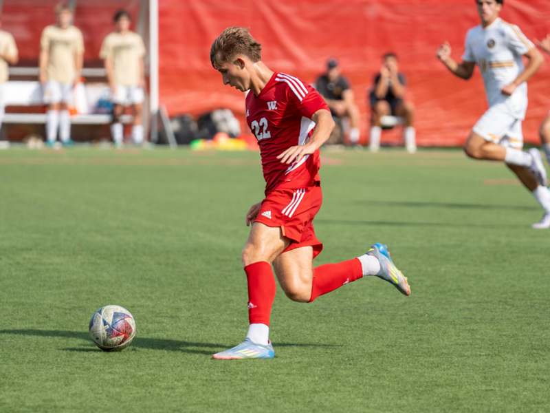 a man in a red uniform kicking a football ball