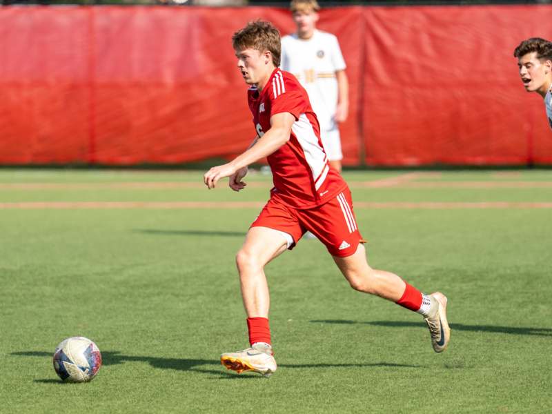 a man in a red uniform kicking a football ball