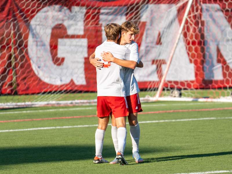 two men hugging on a field