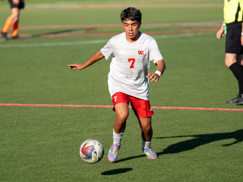 a boy kicking a football ball