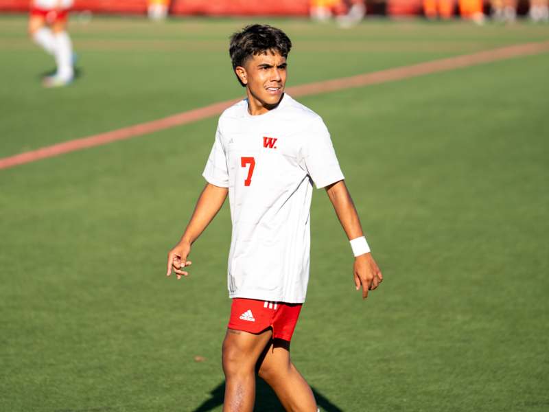 a man in a white shirt and red shorts