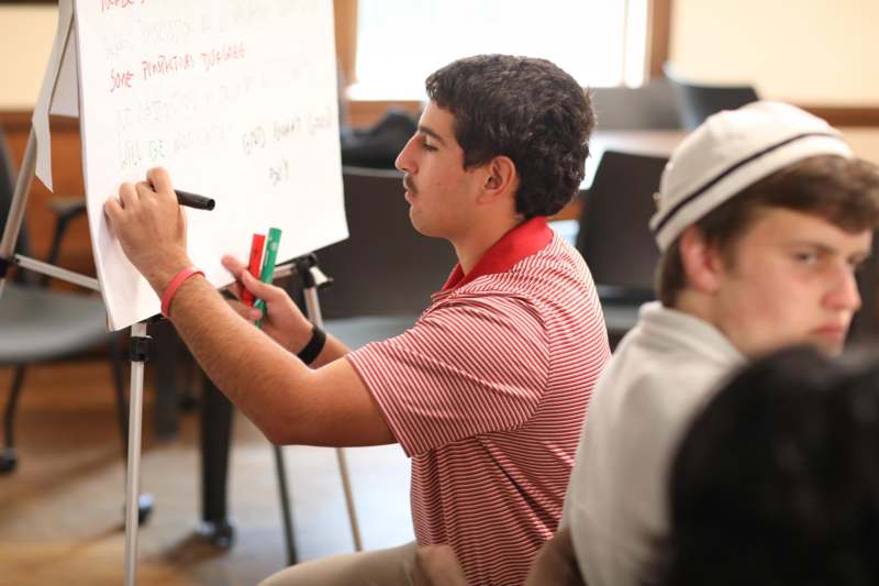 a man writing on a white board