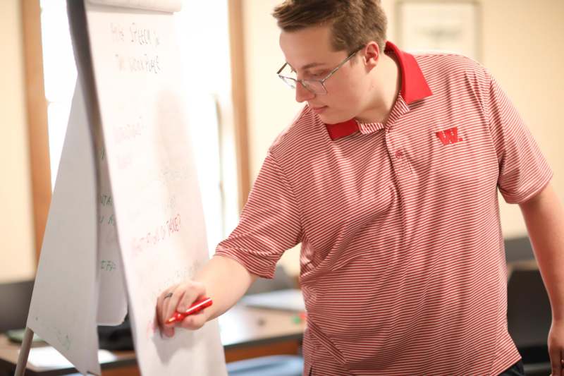 a man writing on a white board