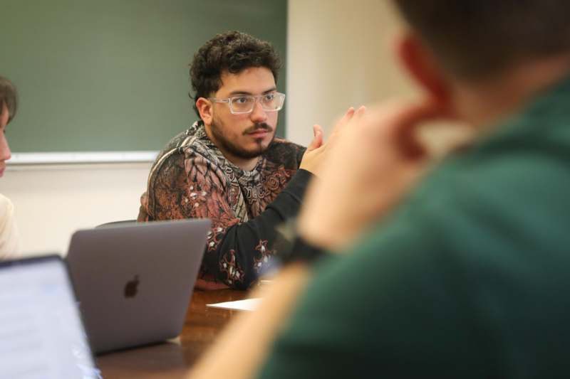 a man sitting at a table with a laptop