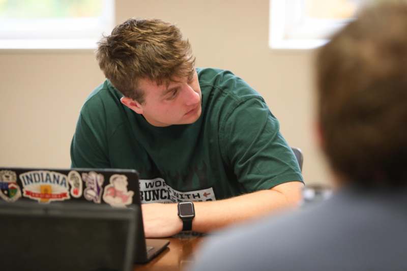 a man sitting at a table with a laptop