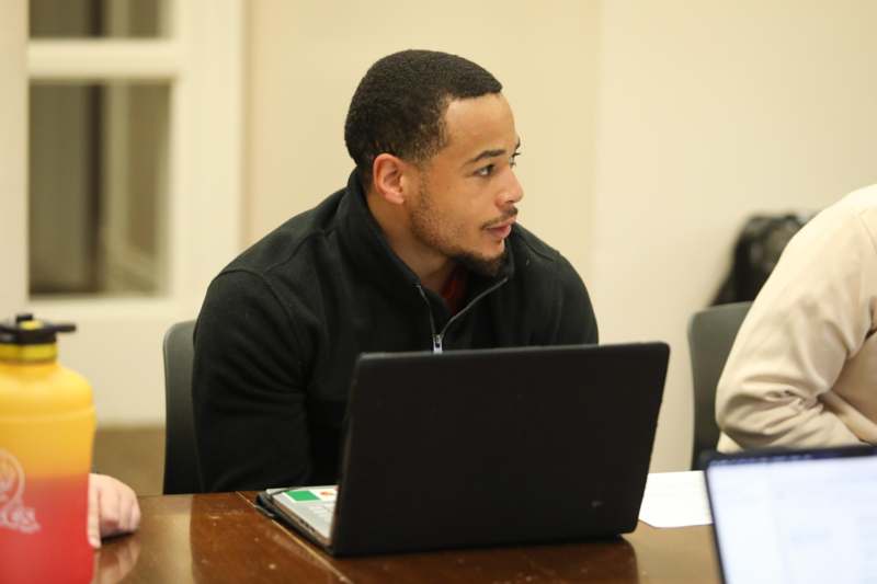 a man sitting at a table with a laptop