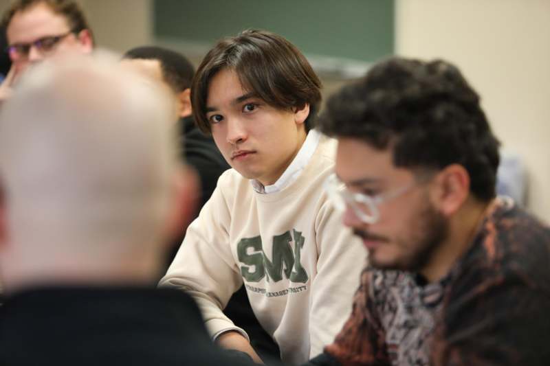 a man sitting in a room with other people