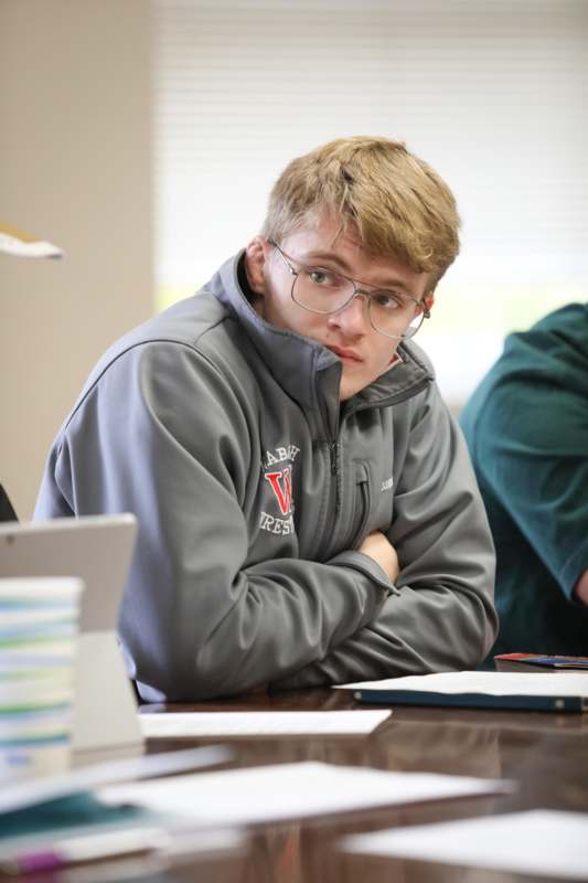 a man with glasses sitting at a table
