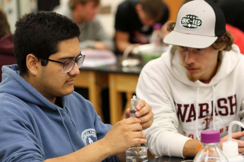 a man holding a plastic bottle with a person holding a plastic bottle