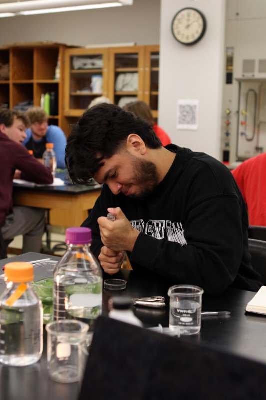 a man sitting at a table with a beaker