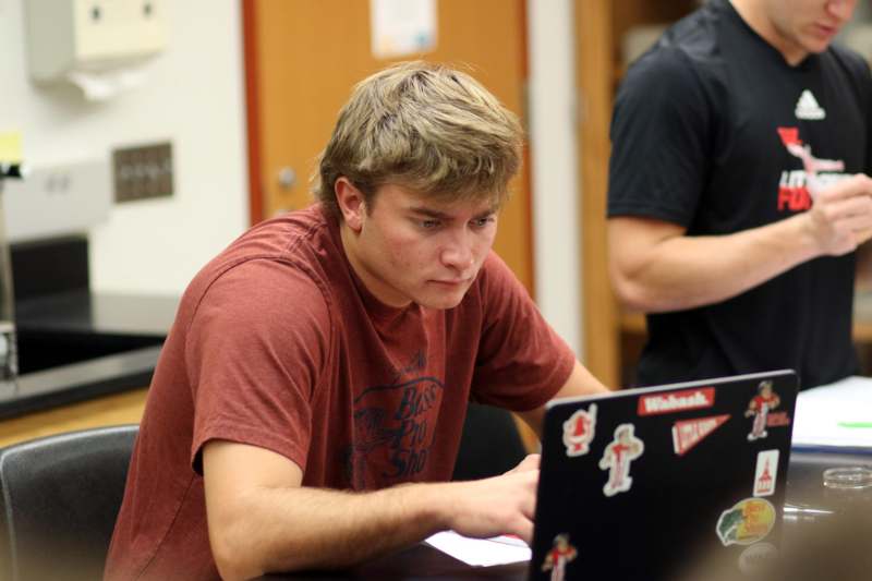a man sitting at a table with a laptop