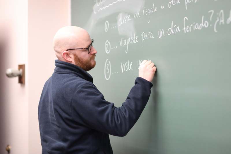 a man writing on a chalkboard