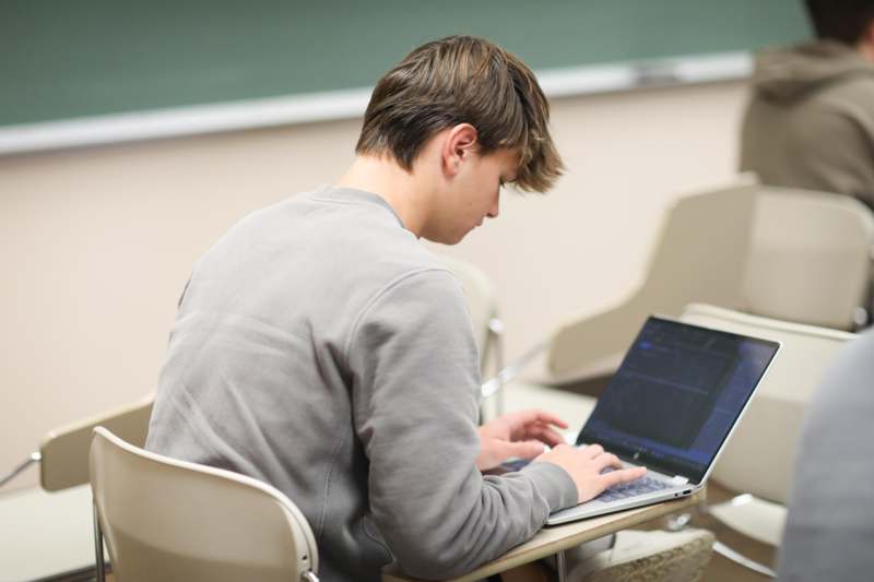 a man sitting at a desk using a laptop