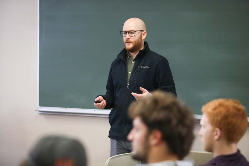 a man standing in front of a chalkboard