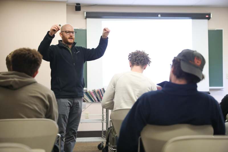 a man standing in front of a whiteboard