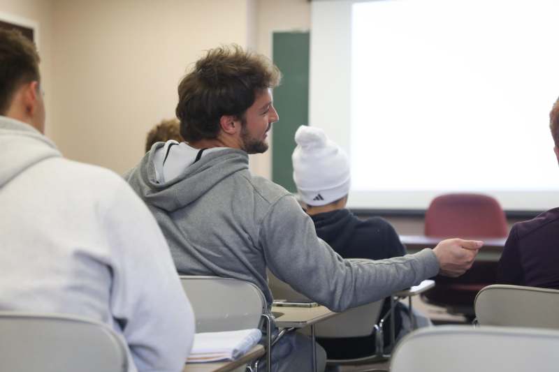 a man in a white beanie sitting at desks