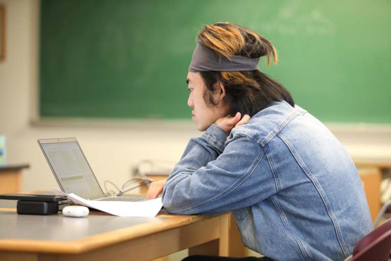 a man sitting at a desk with a laptop