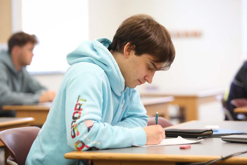 a man writing on a piece of paper