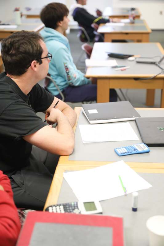 a man sitting at a table with a calculator and papers