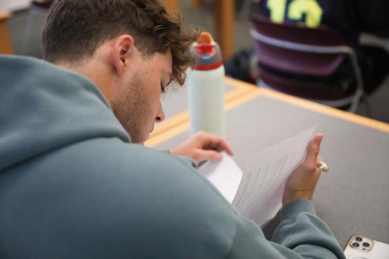 a man sitting at a table looking at a piece of paper