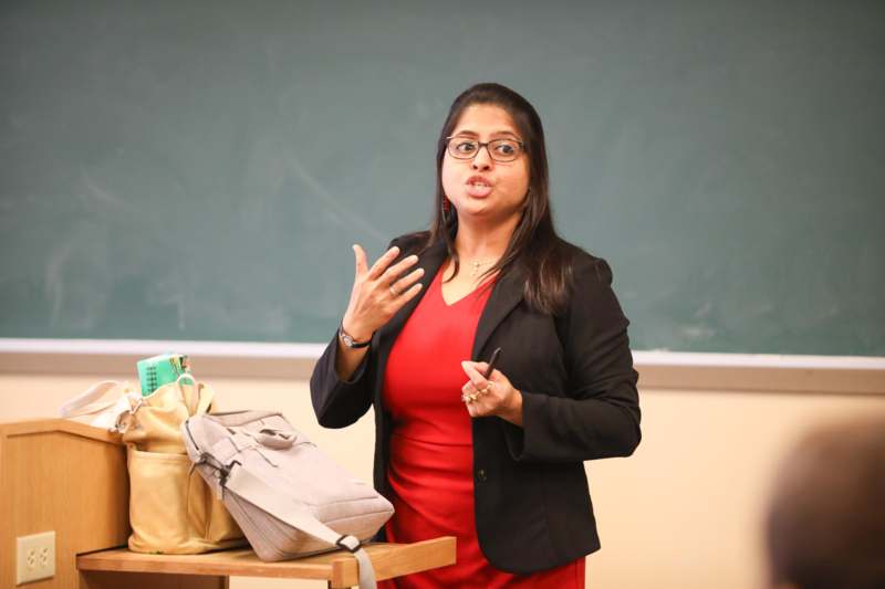 a woman in a red dress standing in front of a chalkboard