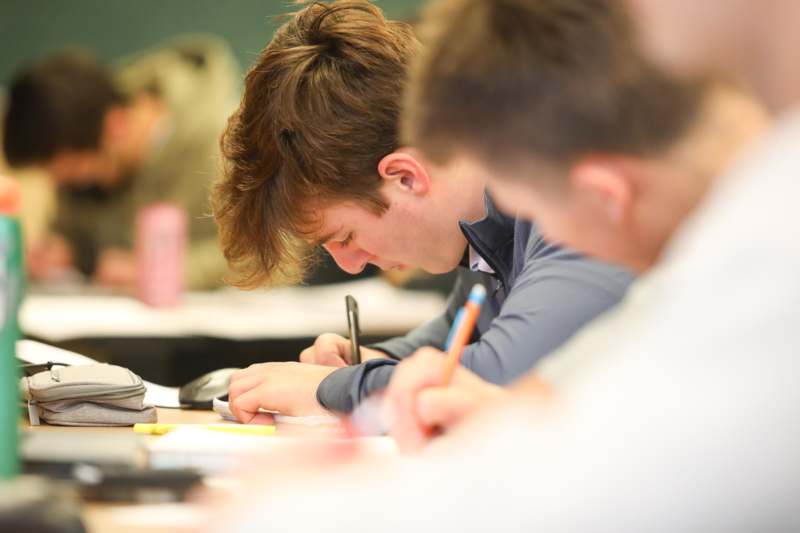 a group of people writing on paper