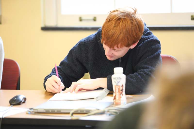 a boy writing on a book