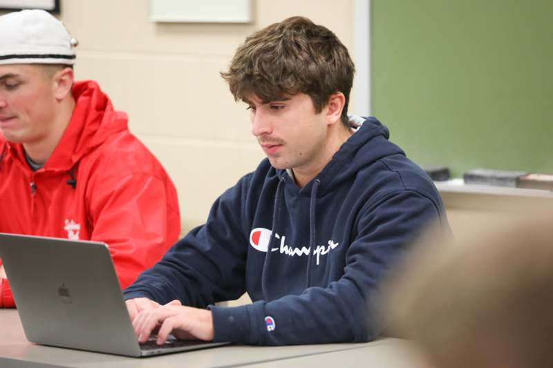 a man sitting at a table using a laptop