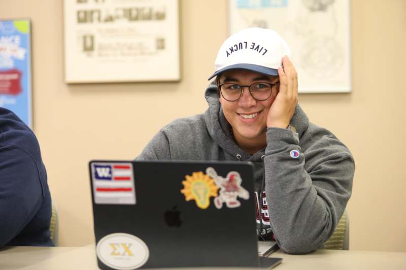 a man sitting at a table with a laptop