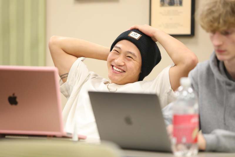 a man smiling with his hands behind his head