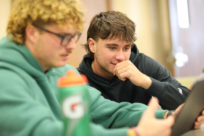 a group of men looking at a cellphone